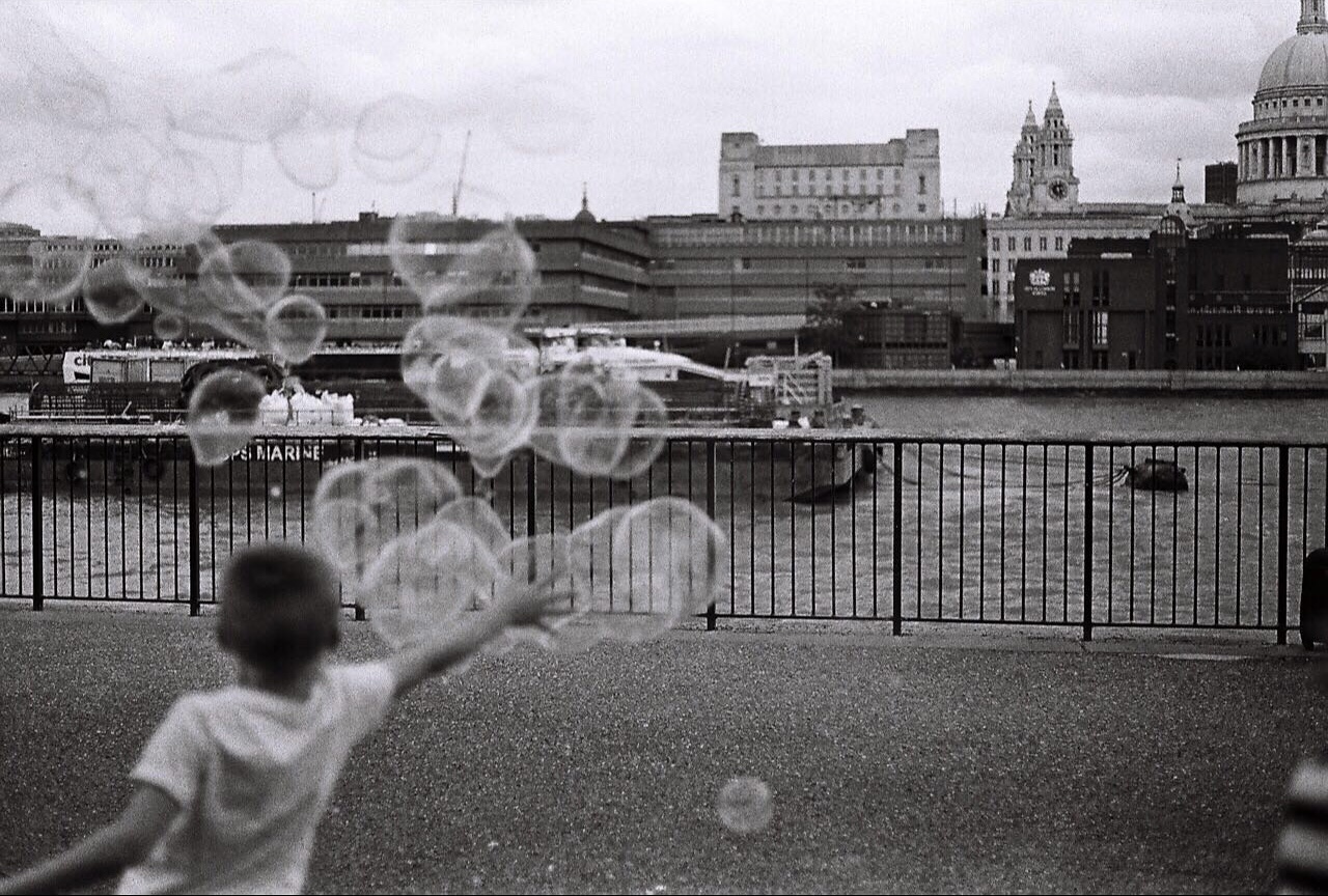 Black and white riverfront photograph with bubbles