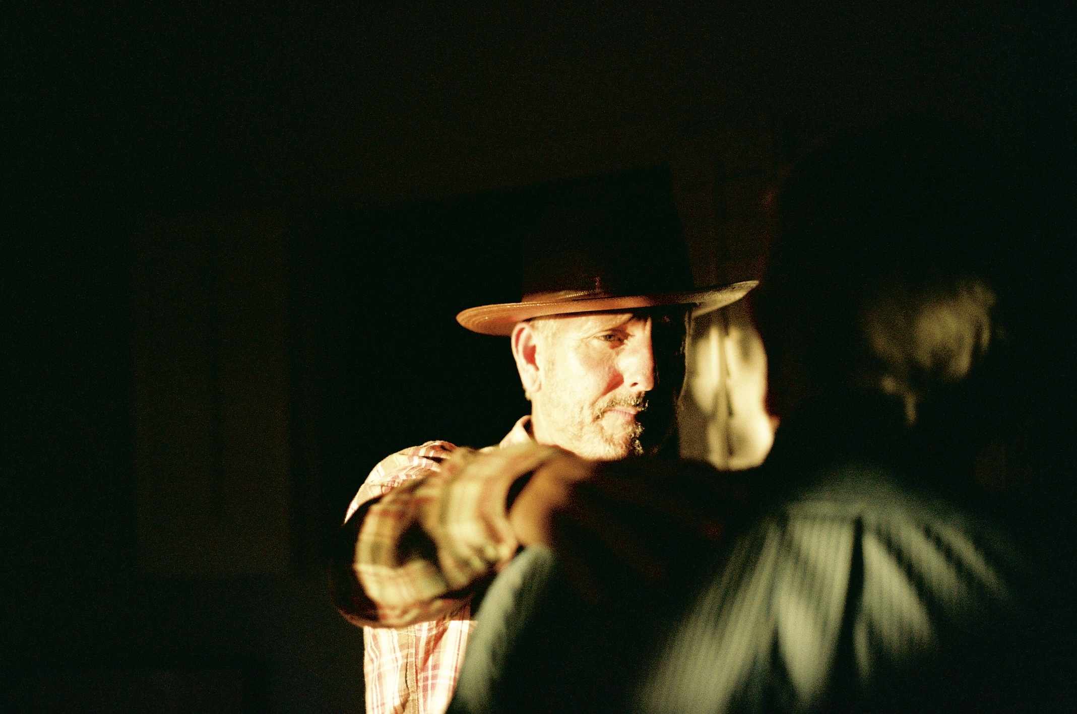 Warmly lit portrait of a man in a hat